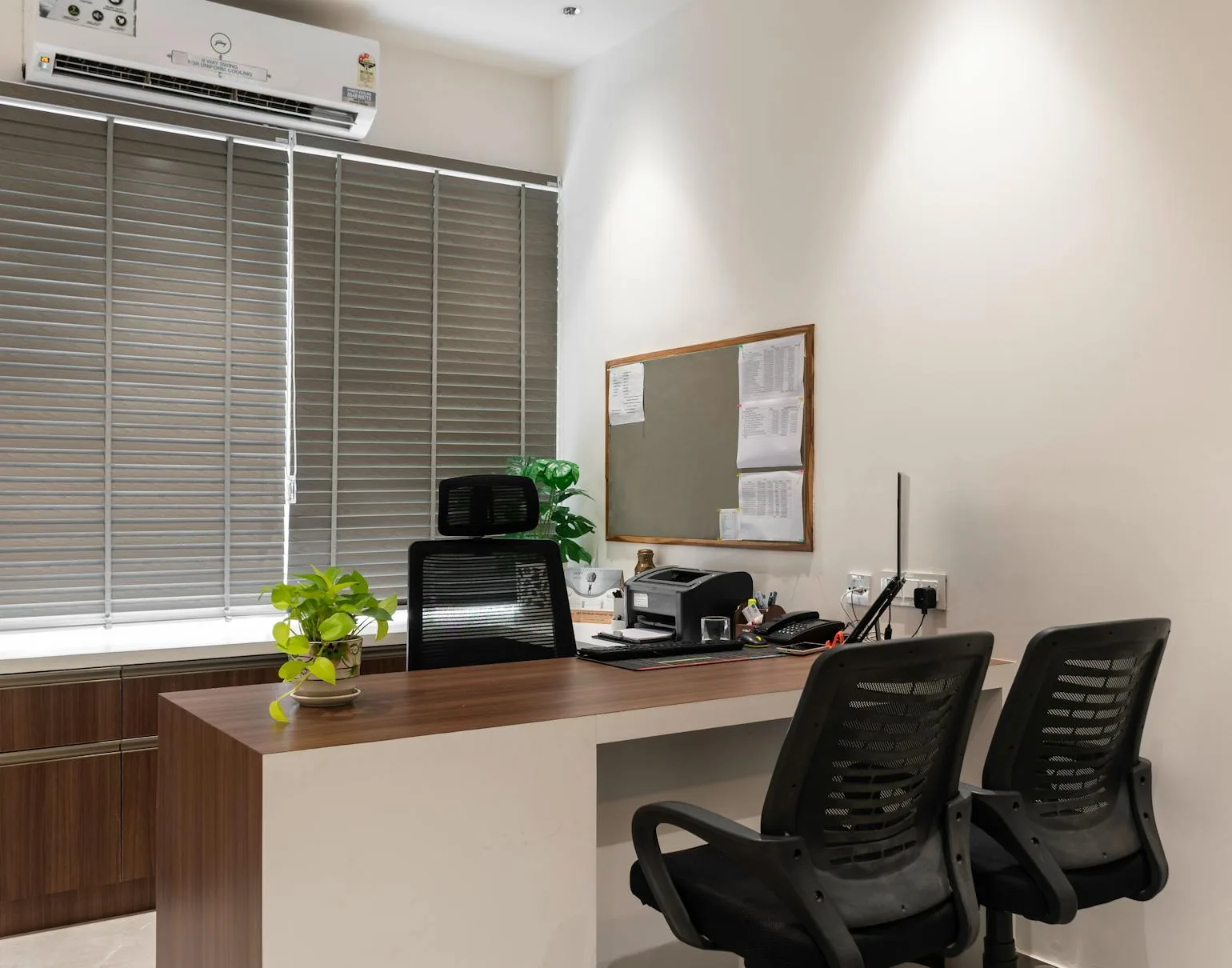 Minimal office interior with a calm desk setup, chairs, and soft natural light.