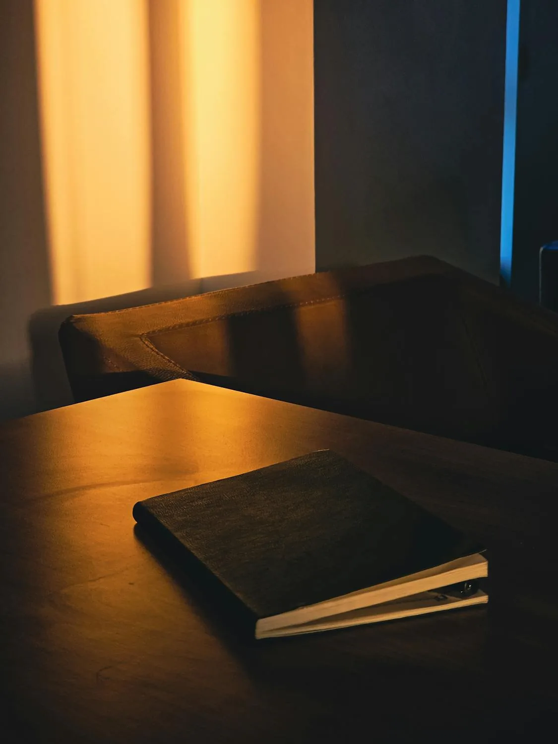 Notebook resting on a wooden desk in soft evening light.