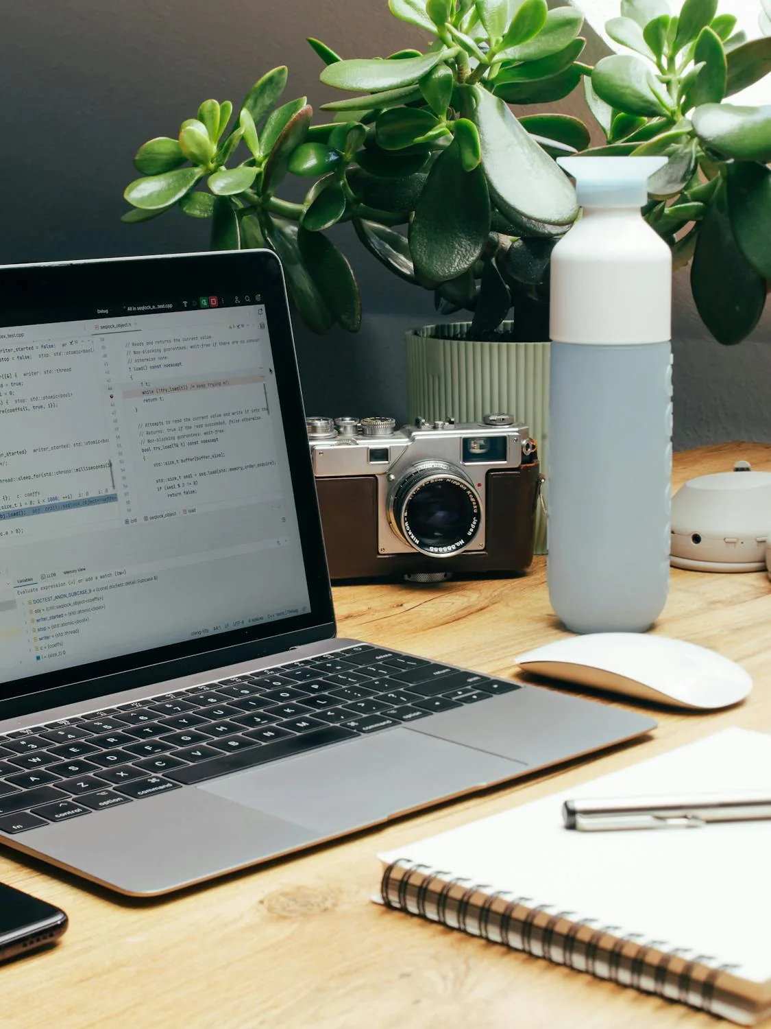 Calm home office desk with a laptop, notebook, and natural styling details.