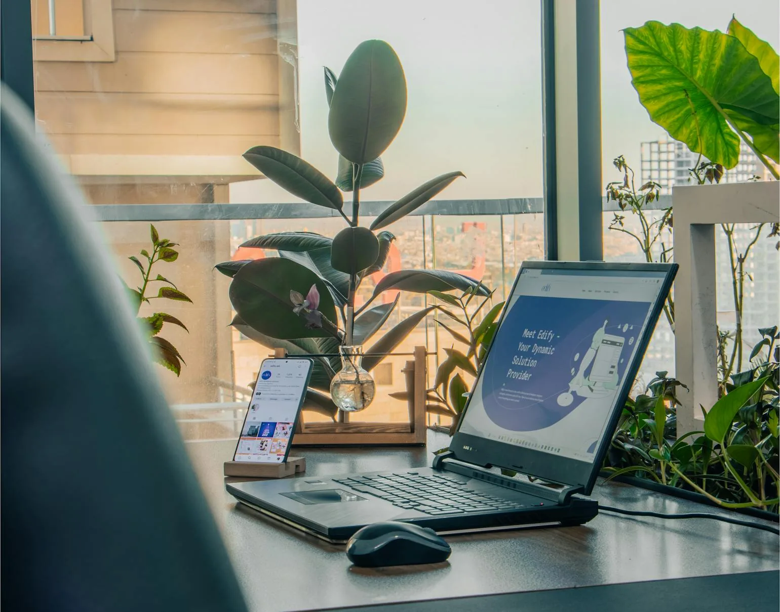 Bright office workspace with a laptop, plants, and natural light.